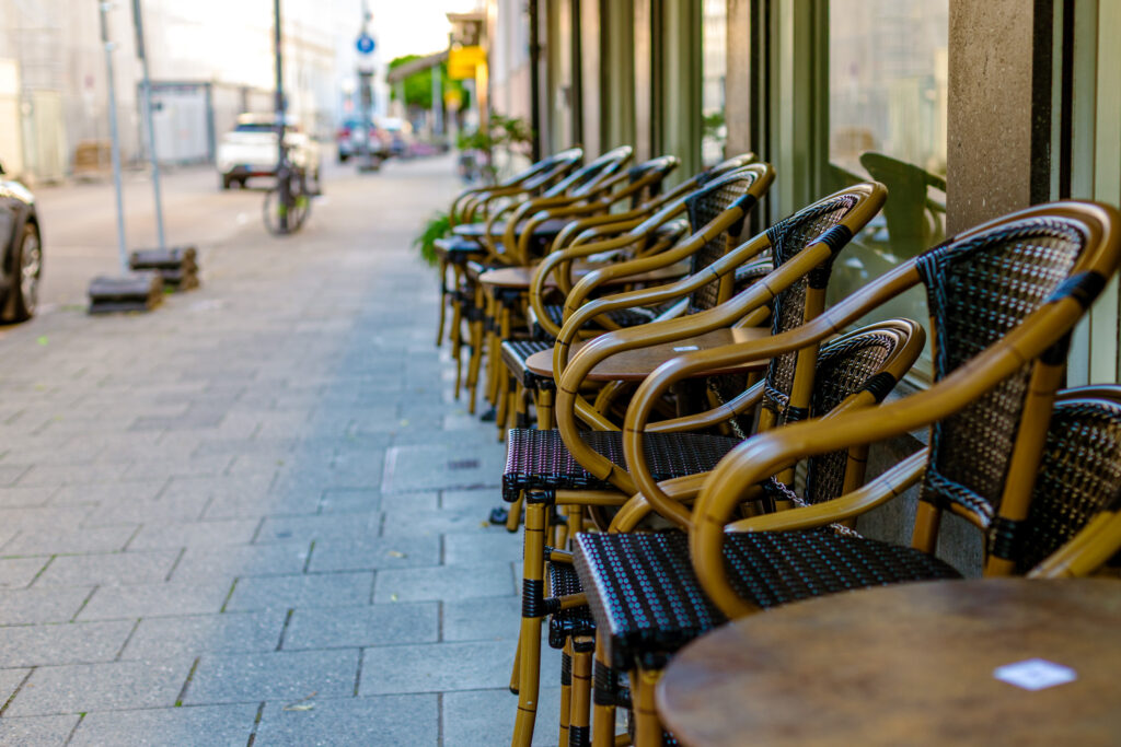 Eine Reihe aus aufgestapelten Stühlen vor einem Cafe